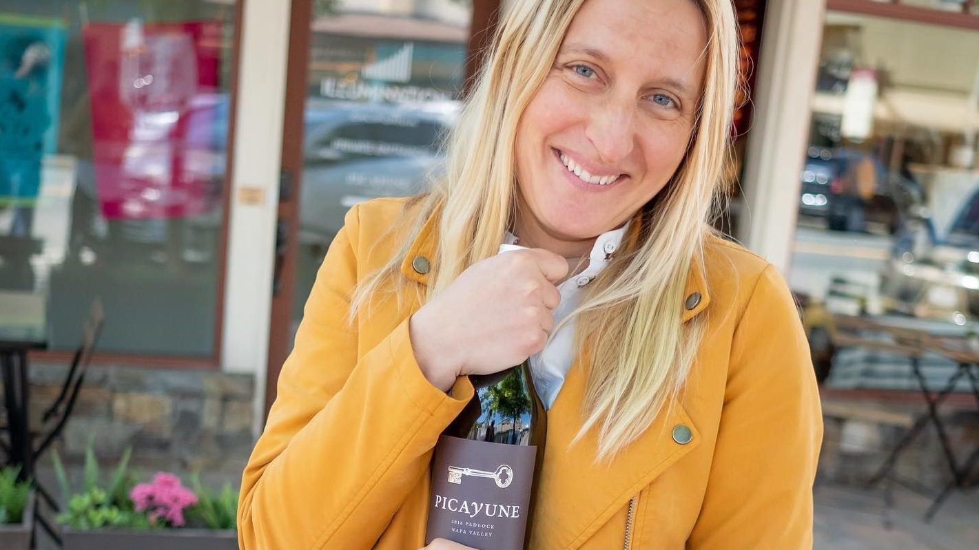 Claire Weinkauf holding a Picayune wine bottle