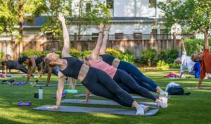 group of people outside practicing yoga