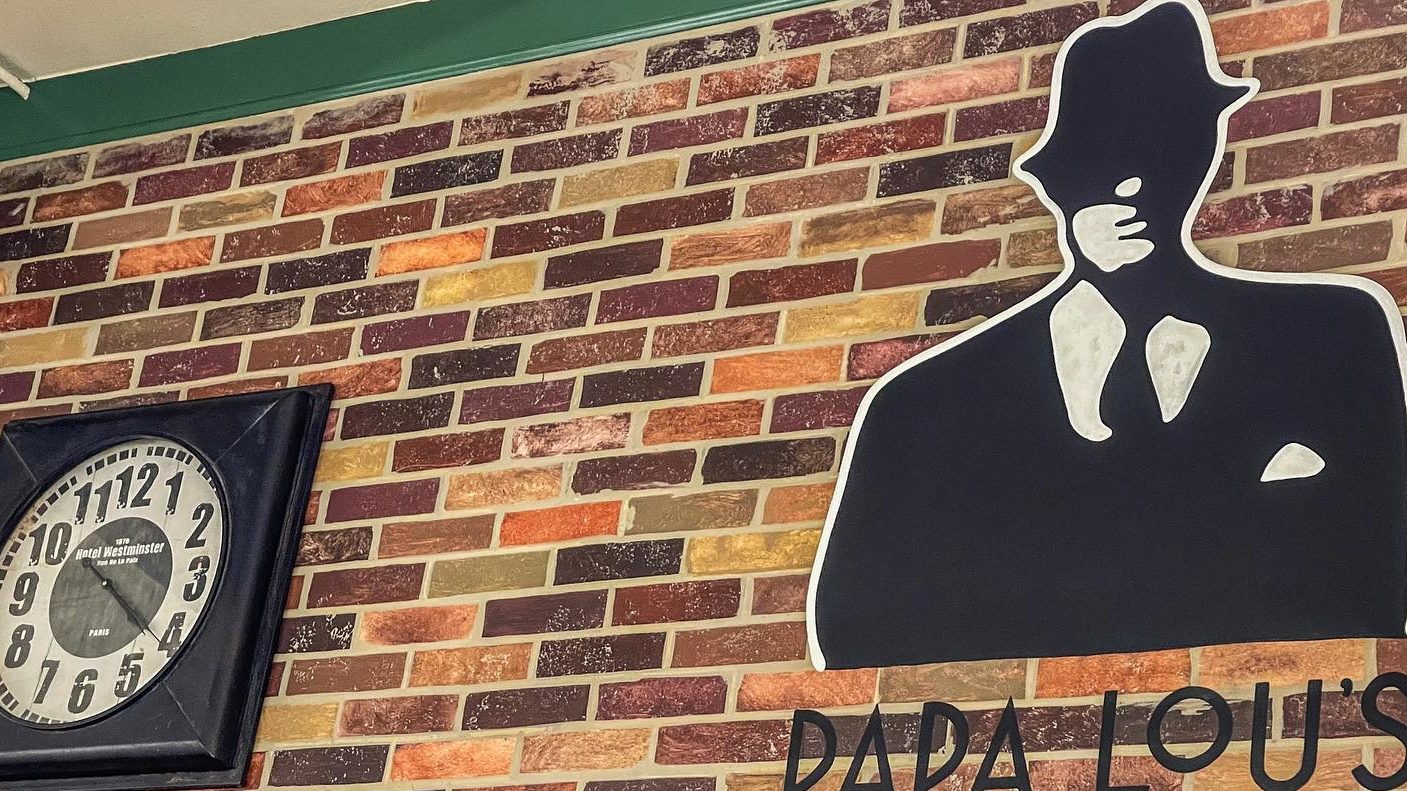 close up of papa lou's logo on wall and clock