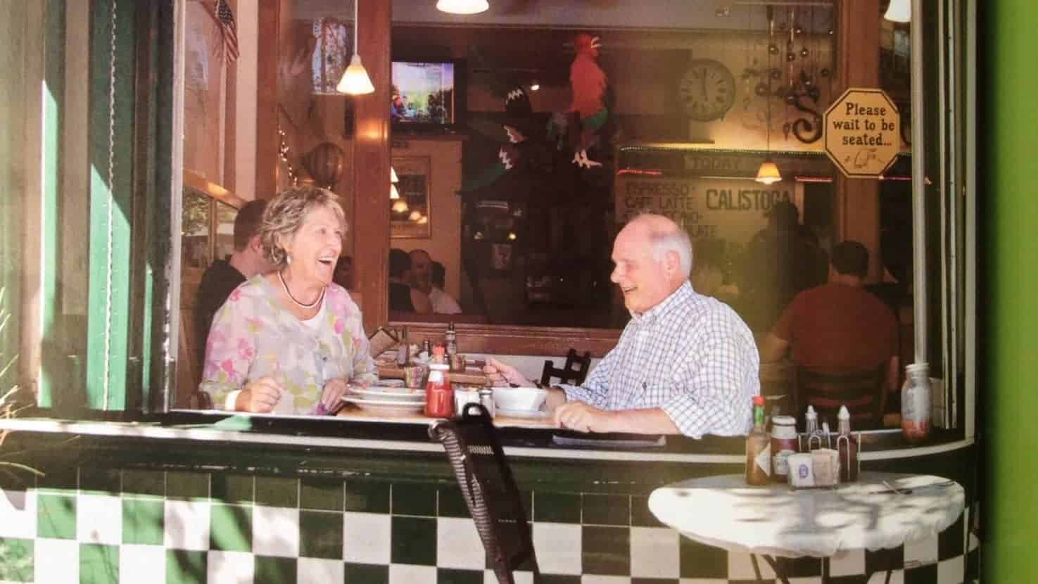 view from outside window looking at couple having meal together