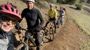 friends smiling on bikes on trail