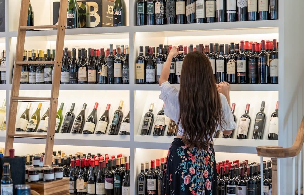 girl picking wine from store selection