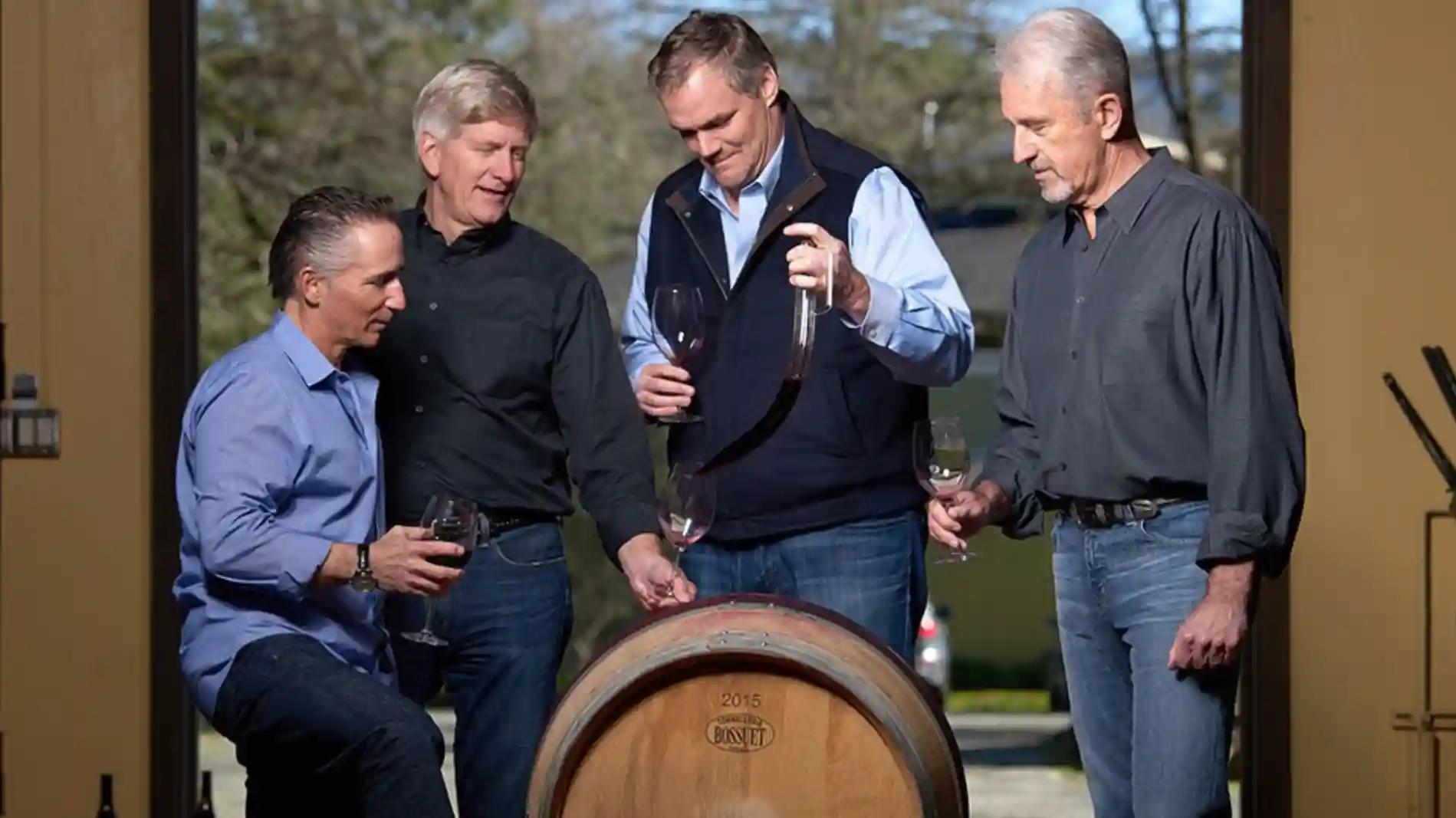 Winemakers tasting wine from inside barrel