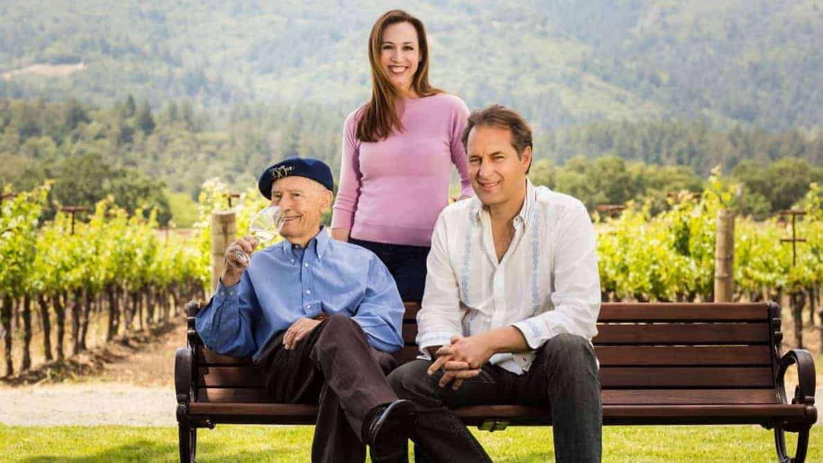 grgich family sitting on bench in front of vineyards