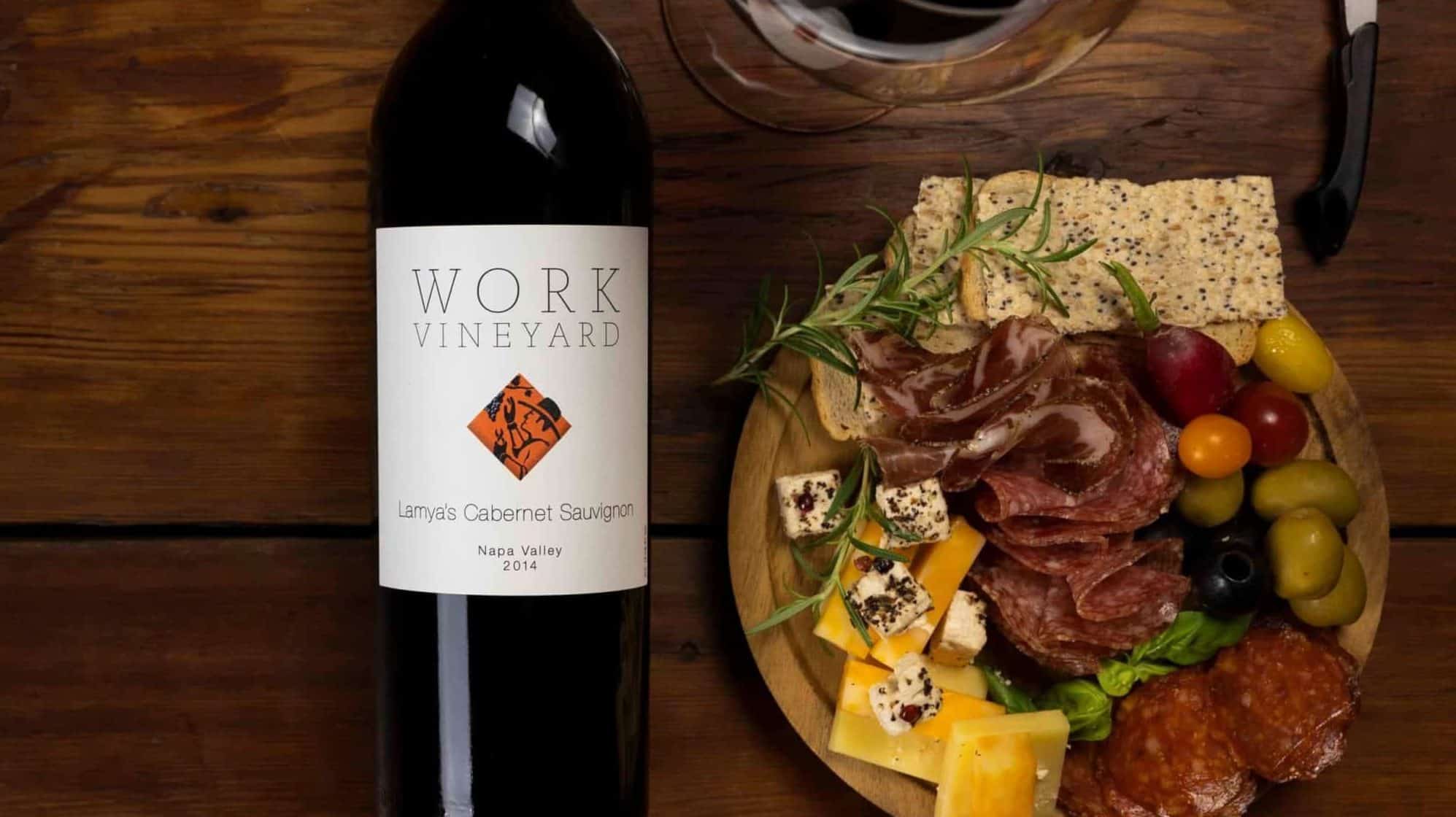 Work vineyard bottle by plate of cheese