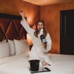 woman opening bottle of champaign in room