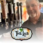 man giving thumbs up by beer taps with The L.A.B. logo