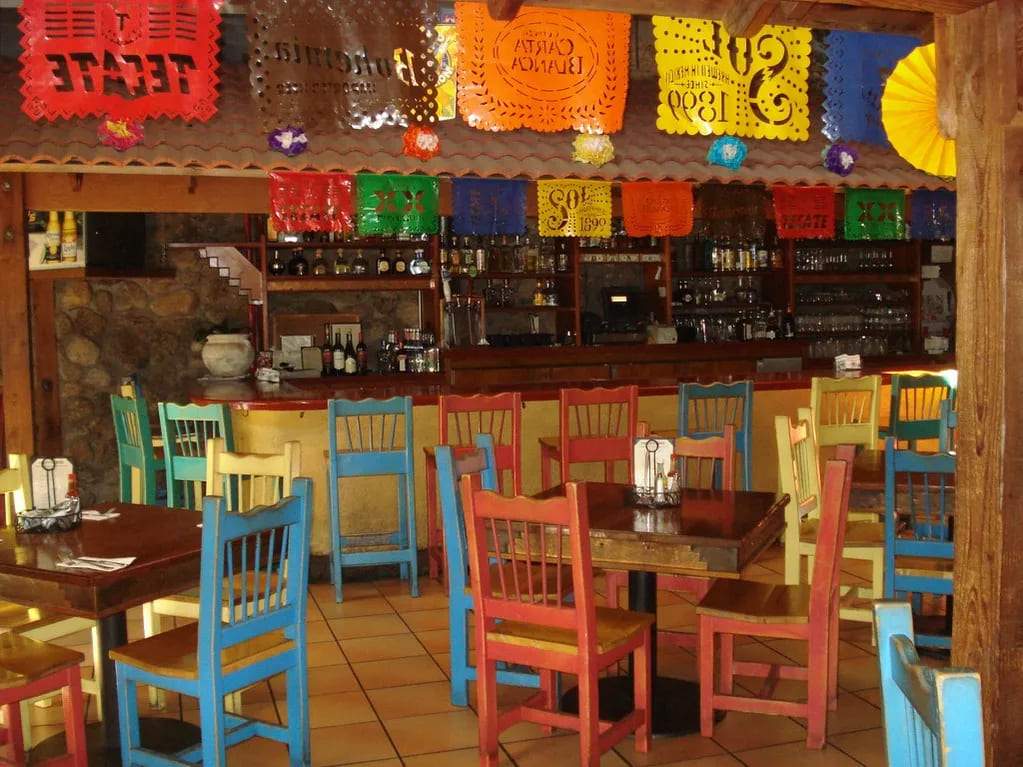 photo of interior of pacifico restaurant with colorful chairs and papel picado