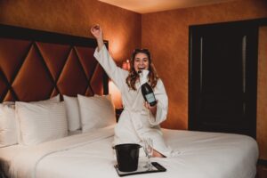 woman popping champagne on roman spa resorts bedroom