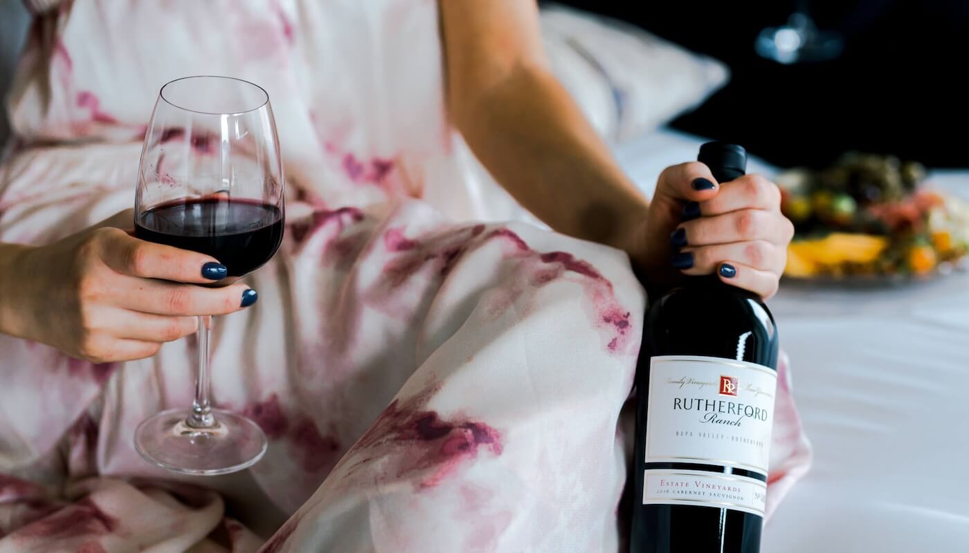 woman holding wine bottle and wine glass