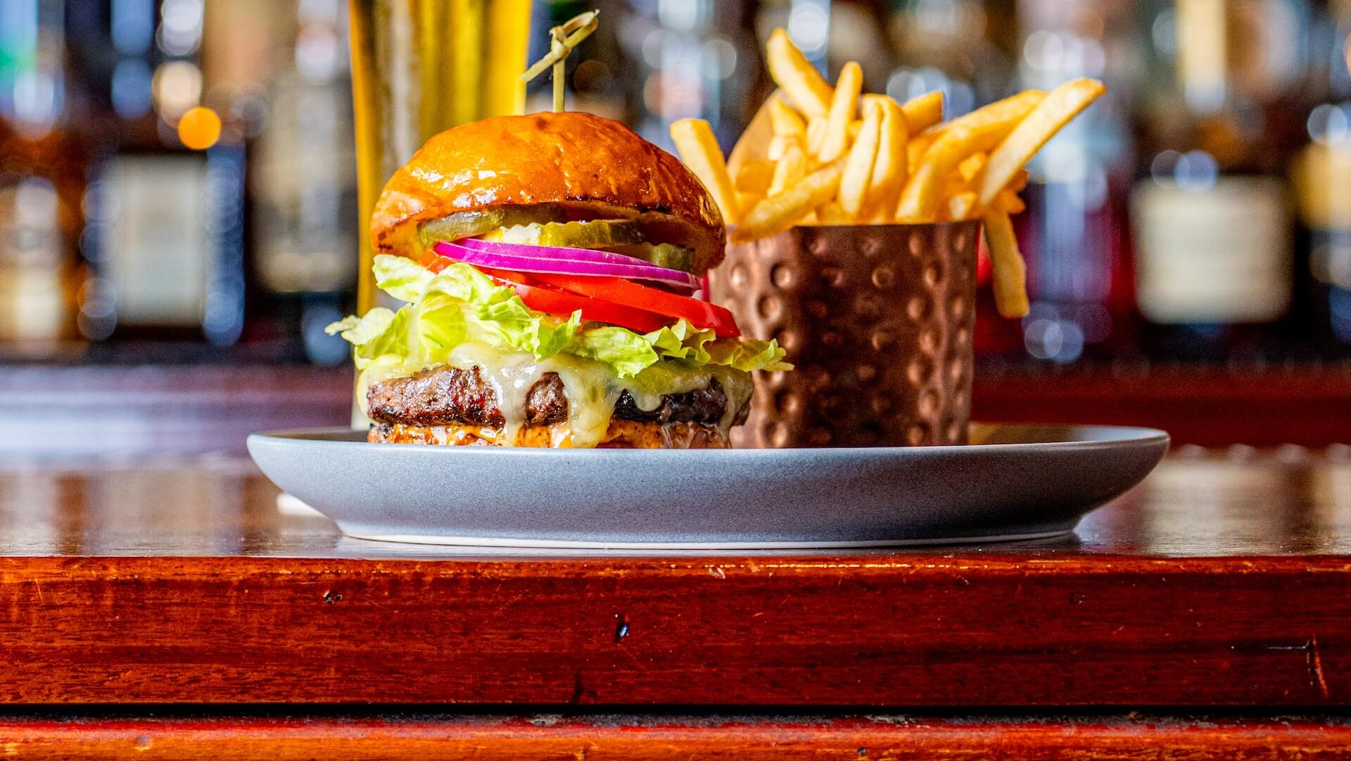 burger and fries and beer on a bar