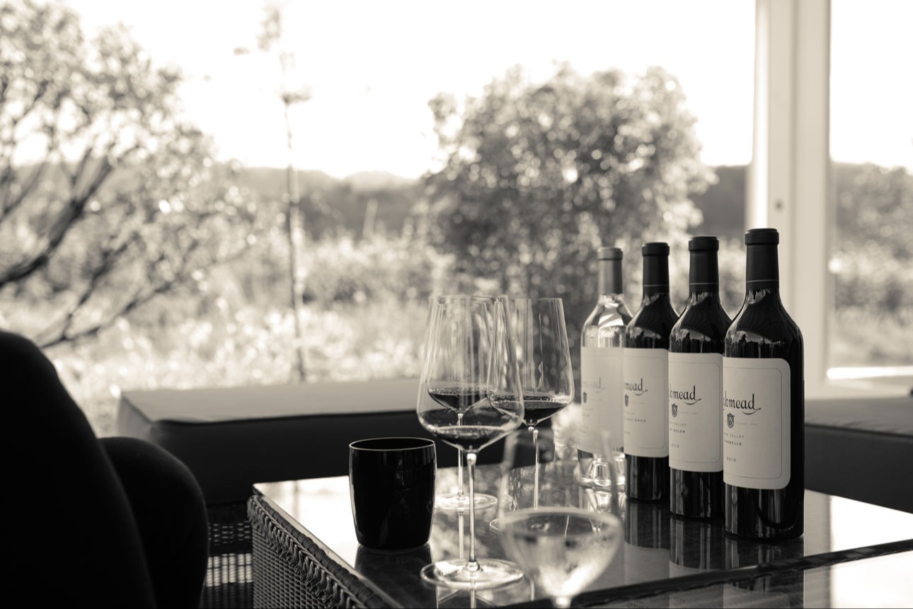 table with vineyard view and wine bottles and glasses on table