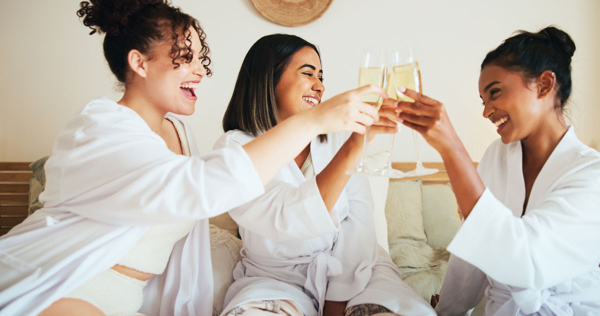 three girls at a spa weekend enjoying robes and champgane