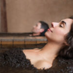 woman and man relaxing on mud baths side by side