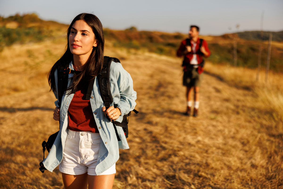 women and man hiking in the hills at sunset