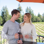 couple on balcony at schweiger clinking wine glasses