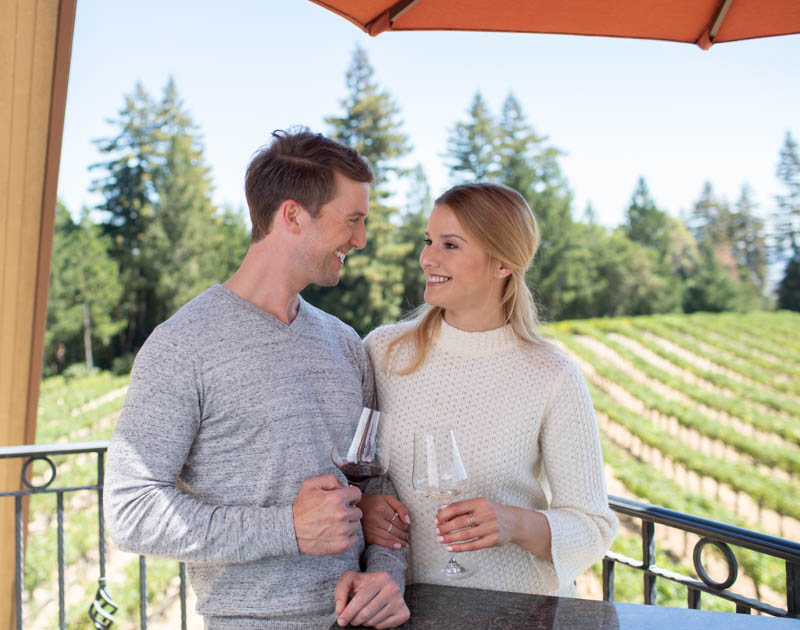 couple on balcony at schweiger clinking wine glasses